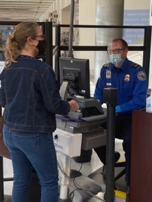 A TSA officer reads a traveler’s ID from a credential authentication technology unit at Dayton International Airport